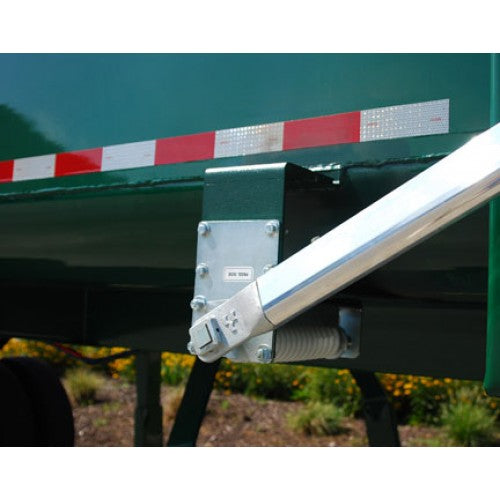 Aluminum tarp arm attached to the side of a green dump truck bed as part of an Easy‑Cover tarping system, showing the mounting bracket, coil spring mechanism, and reflective red‑and‑white safety tape on the truck body.
